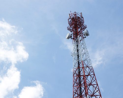 Telecommunications antenna for radio, television and telephone with cloud and blue sky